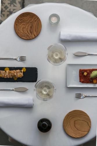 a white table topped with silverware and wine glasses at Mon hotel in Ciutadella