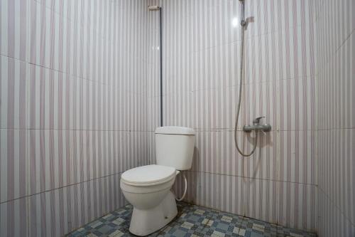 a bathroom with a toilet in a shower stall at Townhouse Oak Hotel Damar Kurung in Gresik