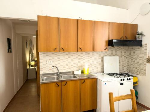 a kitchen with wooden cabinets and a sink and a stove at La casa di Sally in Syracuse