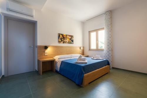 a bedroom with a bed and a desk and a window at Casa Alexandr Azzurra in Pizzo