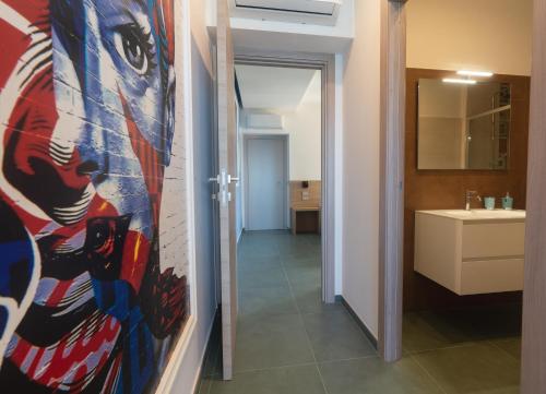 a bathroom with a painting of a woman on the wall at Casa Alexandr Azzurra in Pizzo