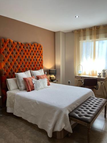 a bedroom with a large bed with an orange headboard at Duplex Jalama II in Moraleja