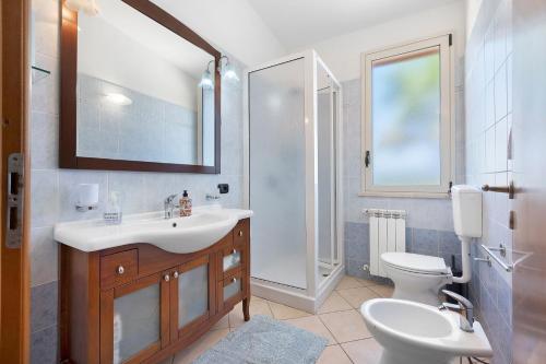 a bathroom with a sink and a toilet and a mirror at Casa Onda Azzurra in Balestrate
