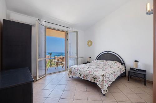 a bedroom with a bed and a view of the ocean at Casa Onda Azzurra in Balestrate