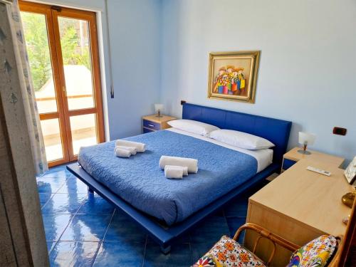 a bedroom with a blue bed with towels on it at Casa Alexandr Piedigrotta in Pizzo