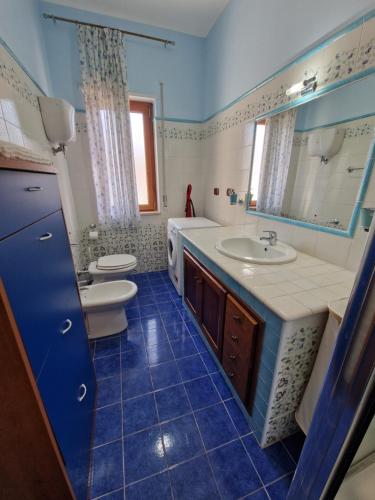 a bathroom with two sinks and a toilet and a mirror at Casa Alexandr Piedigrotta in Pizzo