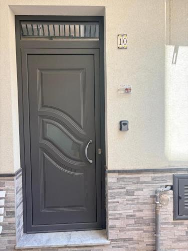 a black door on the side of a building at Il gingillo di Alice by Maniel Beach Hotel in Letojanni