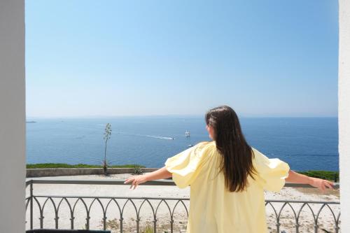 a woman standing on a balcony looking at the ocean at Santateresa in Bonifacio