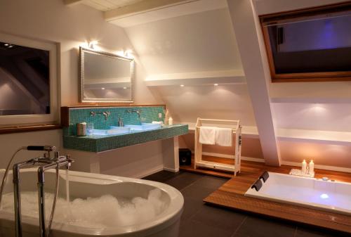 a bathroom with a tub and a sink and a tv at Geinig Amsterdam in Abcoude