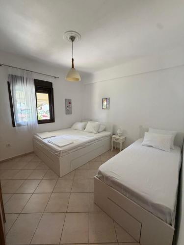 a bedroom with two beds and a window at Aurora Apartment in Afitos
