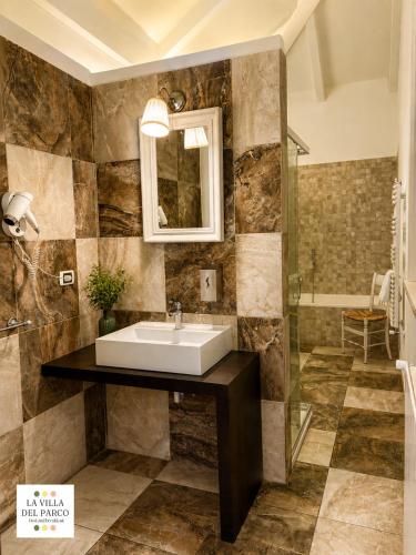 a bathroom with a sink and a glass shower at La Villa Del Parco in Monza
