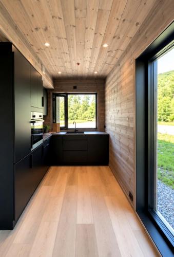 a kitchen with black cabinets and a large window at Mountain View Apartment 201 in Stranda