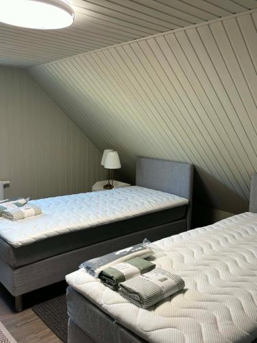 a room with two beds and a phone on top of it at Apartamentai Kelmėje in Kelmė