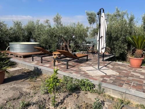 a patio with an umbrella and chairs and a table at la Tana di Luna in Adrano