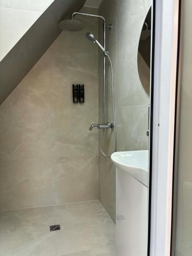a bathroom with a shower and a sink at Apartamentai Kelmėje in Kelmė