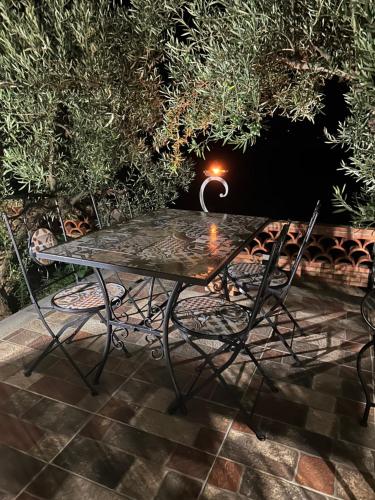 a table and chairs on a patio at night at la Tana di Luna in Adrano