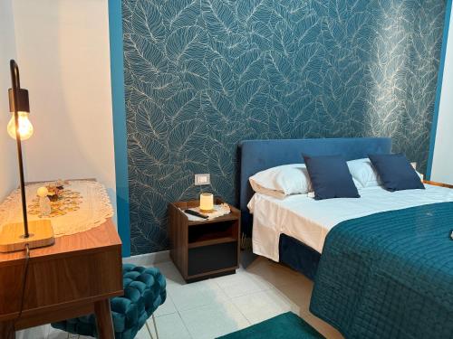 a bedroom with a bed and a table with a lamp at Da Nonna Maria in Roccalumera