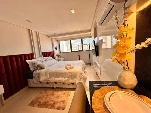 a bedroom with a bed and a table with a sink at Flat Manaira Apart Hotel 1605 in João Pessoa