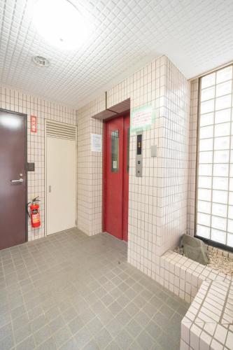 ailed hallway with a red door in a building at CS Residence Chiba in Chiba