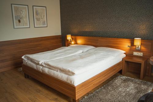 a bedroom with a large bed with two lights on it at Penzión Skalica in Skalica