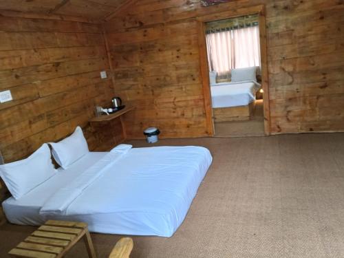 a bedroom with a bed in a wooden cabin at Nenapu Resorts in Oddarahalli