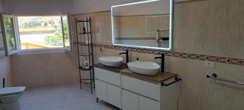 a bathroom with two sinks and a mirror at VILLA La TOSCA in Vega de San Mateo