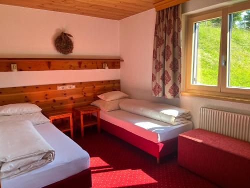 a small room with two beds and a window at Appartements Birkenhof in Lech am Arlberg