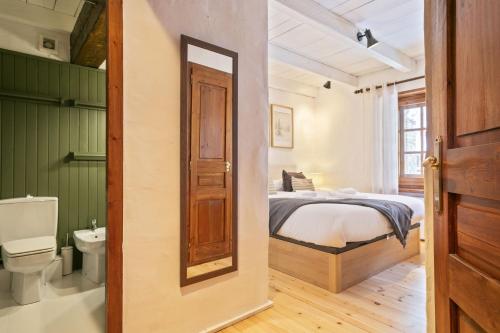 a bedroom with a bed and a bathroom with a toilet at Luderna - Apartamento con terraza Eth Picot in Tredós