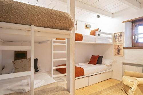 a room with two bunk beds and a couch at Luderna - Apartamento con terraza Eth Picot in Tredós