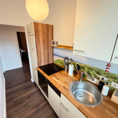 a kitchen with a sink and a counter top at HYGGE HOMES Apartment - 'nordlys' in Lüneburg