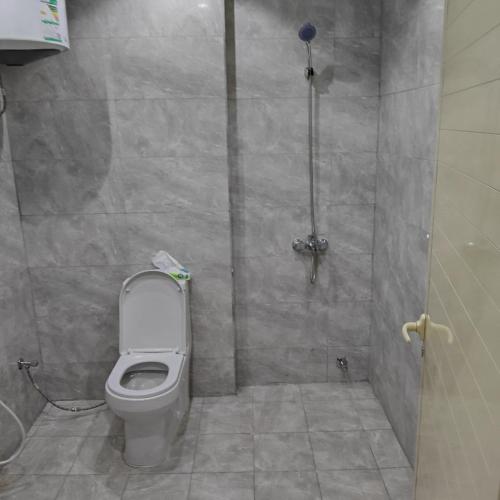 a bathroom with a toilet and a shower at شقق غرفتين جديدة واسعة in Musaylah
