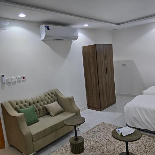 a living room with a couch and a bed at شقق غرفتين جديدة واسعة in Musaylah