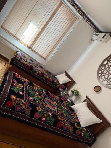 a bedroom with a bed with a bedspread on it at Khiva Indi Guest House in Khiva