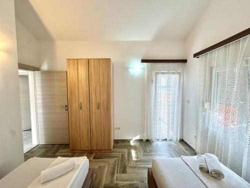 a bedroom with two beds and a wooden door at SeaSide Holiday Apartment in Bijela