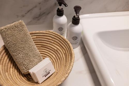 a bathroom with two bottles of soap and a basket at Domiya Estate Ltd in Dodoma