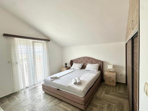 a bedroom with a bed and a large window at SeaSide Holiday Apartment in Bijela