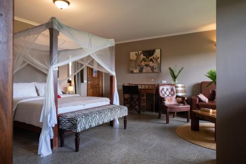 a bedroom with a canopy bed and a living room at Domiya Estate Ltd in Dodoma