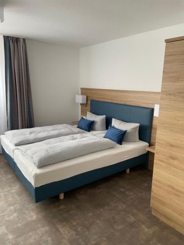 ein Schlafzimmer mit einem Bett mit blau-weißen Kissen in der Unterkunft Pension Arcade in Dresden