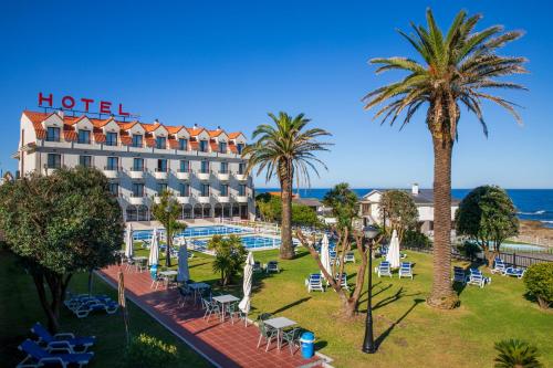 an aerial view of a hotel with palm trees and a resort at Hotel Restaurante Glasgow in Villadesuso