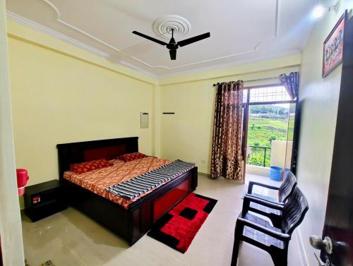 a bedroom with a bed and a ceiling fan at 2BHK Flat in Bhimtal in Bhowāli