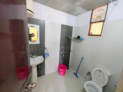 a bathroom with a toilet and a sink at 2BHK Flat in Bhimtal in Bhowāli