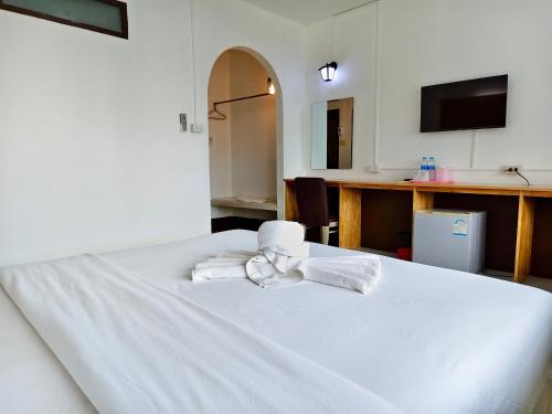 a bedroom with a white bed with towels on it at S2S Queen Trang Hotel in Trang