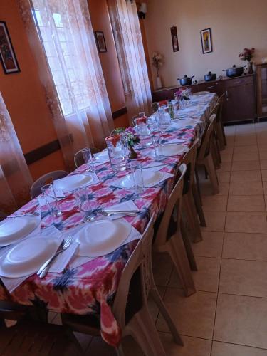 a long table with plates and wine glasses on it at Palm Garden Guest House in Gulu