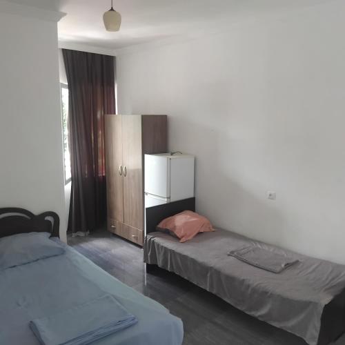a bedroom with two beds and a dresser in it at ULA guest house in Ureki
