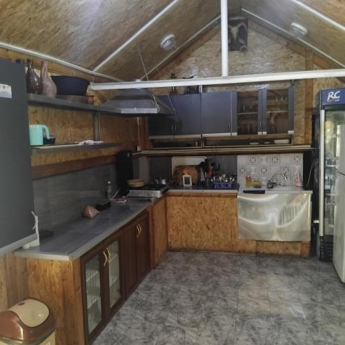 a kitchen with wooden cabinets and a sink at ULA guest house in Ureki