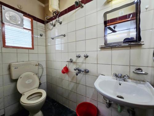 a bathroom with a toilet and a sink at Anandaloke Guest House in Kolkata