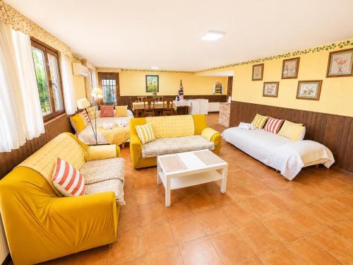 a living room with yellow couches and a table at Casa La Bienvenida con patio y aparcamiento - Apartamentos Aloha Toledo in Nambroca