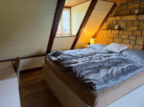 a bed in a room with a stone wall at House Pankraz Jitrava in Rynoltice