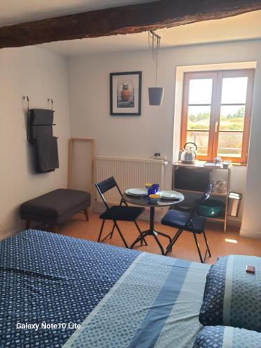 a bedroom with a bed and a table and chairs at Montgrailloux - Chambilly in Chambilly