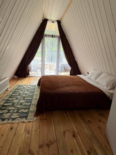 a bedroom with a large bed with a wooden floor at Borjomi Tskhaoba in Borjomi